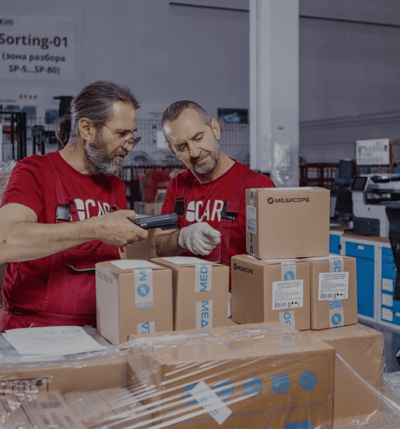 Сотрудники склада маркируют термозавиисмые грузы. Biocard - перевозки грузов с температурным режимом по РФ и миру